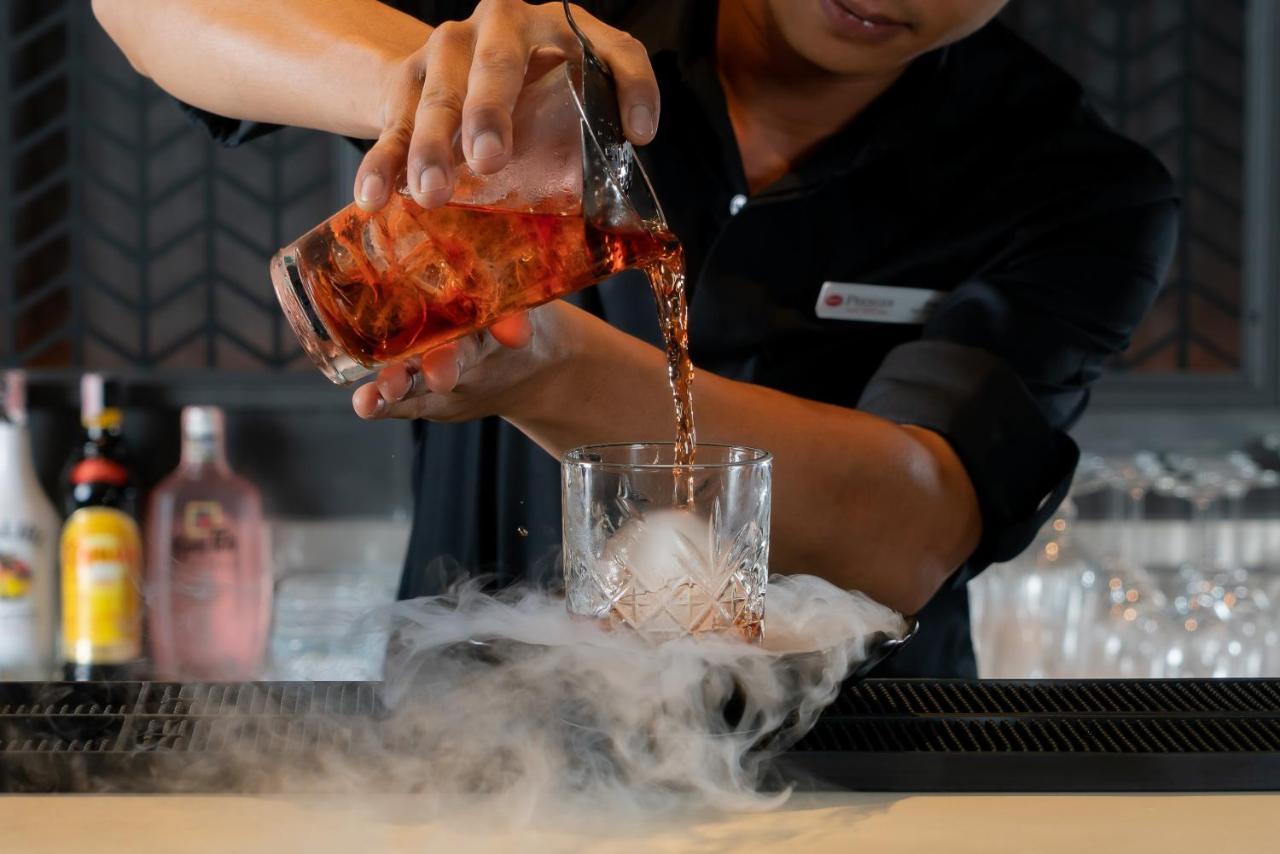 Bayphere Hotel Pattaya Jc Na Chom Thian Εξωτερικό φωτογραφία A bartender pouring a cocktail